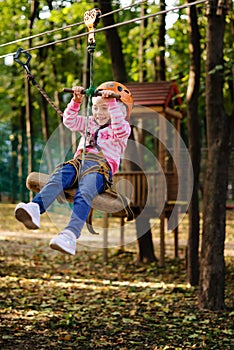 Girl climbing a rope trail in an adventure rope park.