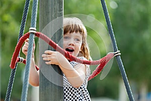 Girl climbing at ropes on playground