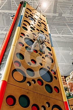 Girl climbing walls in game center, bottom view