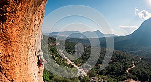 The girl climbs the rock. Climber trains on natural terrain. Extreme sport. Lessons on the street. A woman overcomes a difficult