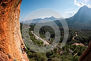 The girl climbs the rock. Climber trains on natural terrain. Extreme sport. Lessons on the street. A woman overcomes a difficult