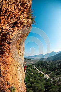 The girl climbs the rock. Climber trains on natural terrain. Extreme sport. Lessons on the street. A woman overcomes a difficult