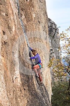 Girl climbs a rock-climbing route. outdoor sports