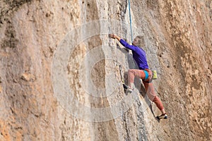 Girl climbs a rock-climbing route. outdoor sports