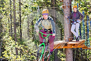 Girl climbs into ropes course. bike