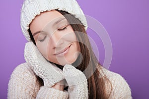 Girl closed eyes and clasped her hands in mittens under her cheek