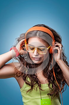 Girl with closed eyes in headphones listening to music.