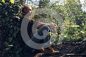 Girl with closed eyes resting, leaning against tree. Tourism Hiking Survival Bushcraft Concept