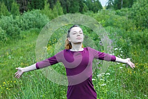 Girl with closed eyes and wide spread arms