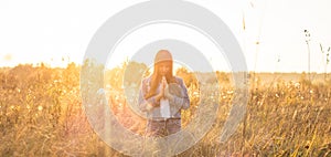 Girl closed her eyes, praying outdoors, Hands folded in prayer concept for faith, spirituality and religion. hope, dreams concept.