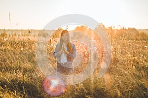 Girl closed her eyes, praying outdoors, Hands folded in prayer concept for faith, spirituality and religion. hope, dreams concept.