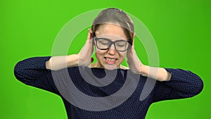 Girl closes her ears. Green screen
