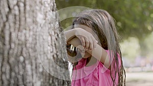 Girl closing eyes with hands and counting out loud