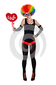 Girl in a clown suit holding a red heart