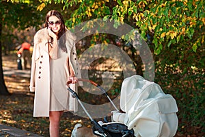 Girl in coat walks with baby and smiles. Outside.