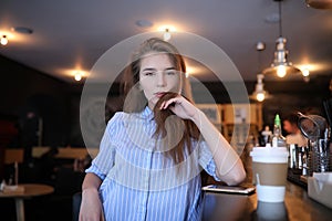 Girl with coffee. Young beautiful girl is sitting in a cafe and