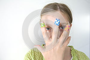 Girl with coloful adhesive plasters on her fingers