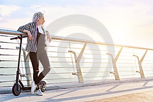 Young woman with colored dreadlocks  riding electric scooter