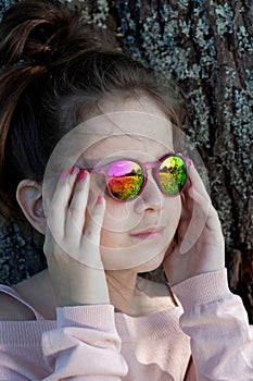 Girl in colored sunglasses close-up.