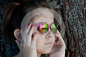 Girl in colored sunglasses close-up.