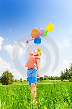 Girl with colorful balloons wears flower circlet