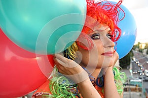 Girl in colorful wig with balloons