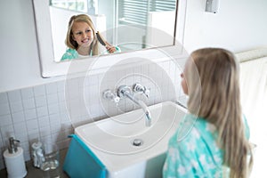 Girl combing her hair in bathroom