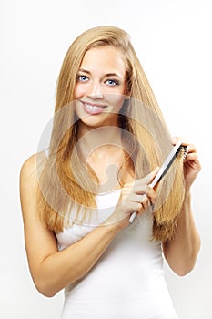 Girl combing of her hair. on gray