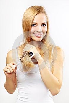 Girl combing of her hair. light background