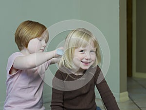 Girl Combing Sister's Blond Hair