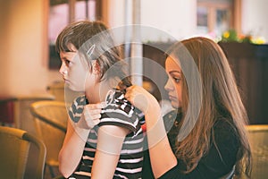 The girl combs her hair to her friend