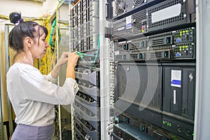 The girl commutes the wires of powerful Internet routers. A woman switches the cable in the server room. The system administrator