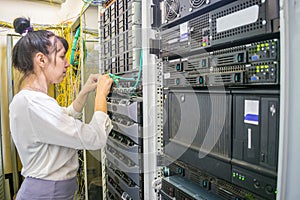 The girl commutes the wires of powerful Internet routers. A woman switches the cable in the server room. The system administrator photo