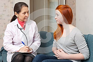 Girl complaining to doctor about abdominal pain