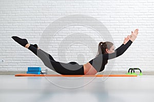 the girl conducts a home workout stretching to strengthen her back