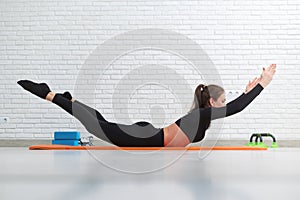 the girl conducts a home workout stretching to strengthen her back