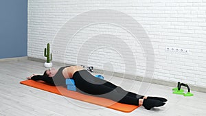 the girl conducts a home workout stretching to strengthen her back