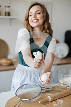 Girl confectioner holding chicken eggs in her hands