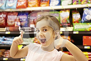 Girl in confectionery supermarket confectionery aisle