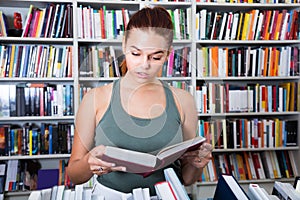 Girl considers the book in a bookstore