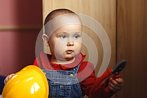 Girl with construction tools. Little girl in jeans dress. little girl in a helmet. Child protection and safety. baby building.