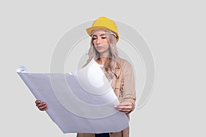 Girl Construction Worker Holding House Plan in Hands Watching at it. Girl Architect Holding Blueprints. Yellow Hard