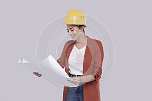 Girl Construction Worker Holding House Plan in Hands Watching at it. Girl Architect Holding Blueprints. Yellow Hard