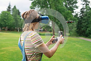 The girl controls a quadrocopter in the park with the help of a VR helmet. The concept of virtual reality. extra reality