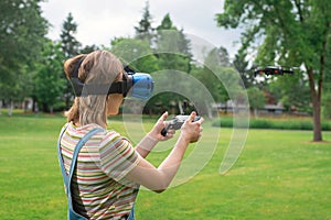 The girl controls a quadrocopter in the park with the help of a VR helmet. The concept of virtual reality. extra reality