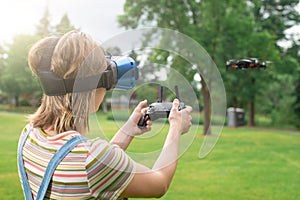 The girl controls a quadrocopter in the park with the help of a VR helmet. The concept of virtual reality. extra reality