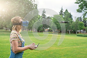 The girl controls a quadrocopter in the park with the help of a VR helmet. The concept of virtual reality. extra reality