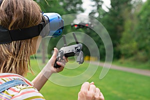 The girl controls a quadrocopter in the park with the help of a VR helmet. The concept of virtual reality. extra reality