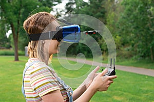 The girl controls a quadrocopter in the park with the help of a VR helmet. The concept of virtual reality. extra reality