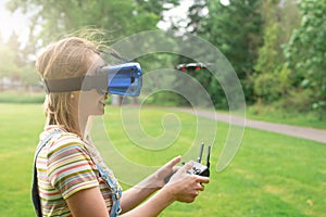 The girl controls a quadrocopter in the park with the help of a VR helmet. The concept of virtual reality. extra reality